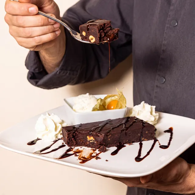 Photo du chef qui présente le brownie et sa chantilly à la cuillère, dessert fait maison à la Brasserie l'Échalote